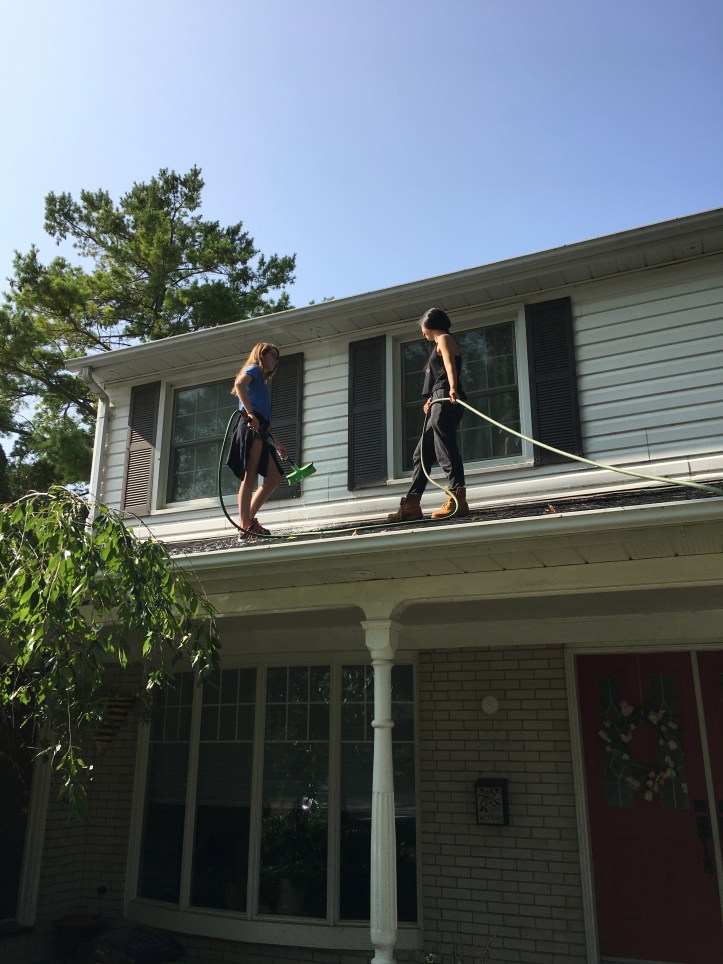 Window cleaners on the roof of a house