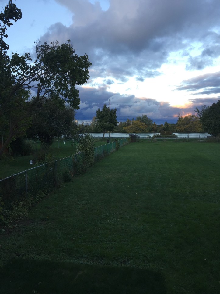 View of canal across yard with setting sun 